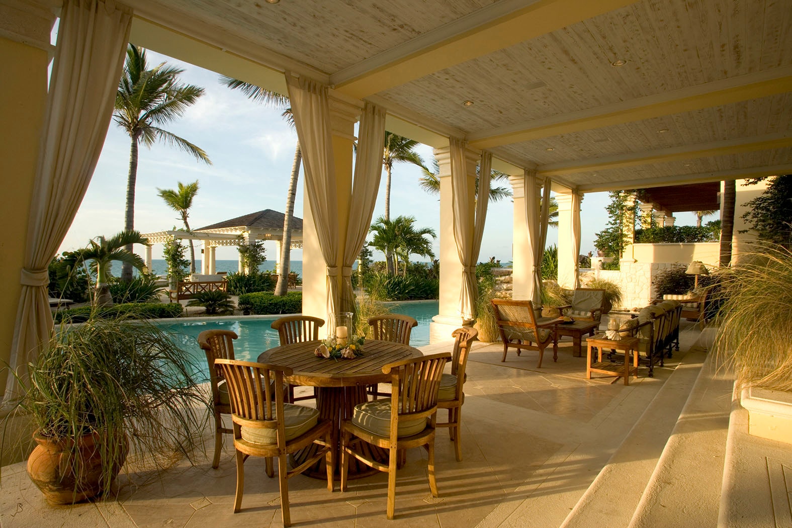 Oceanfront estate loggia with pool at dusk