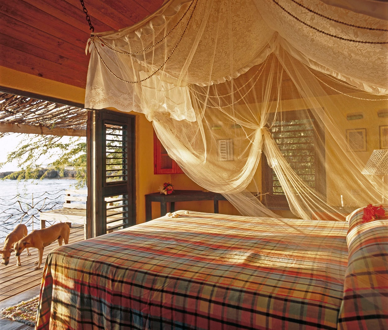 Waterfront resort bedroom with canopy netting and plaid bedding